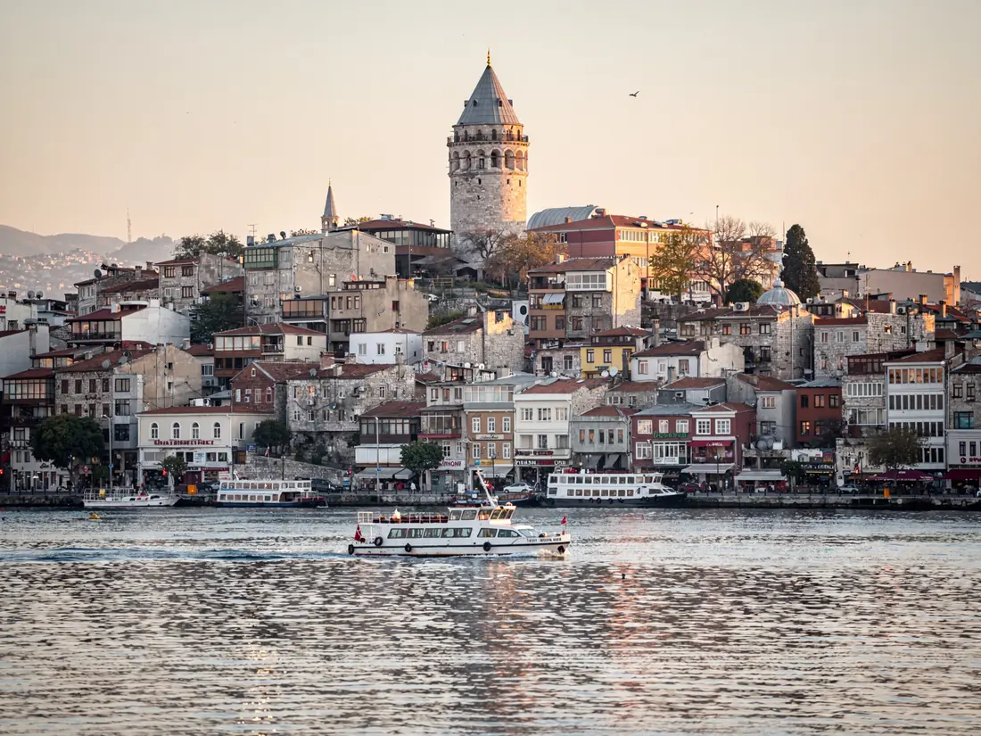 Galata Tower above the old town, seen across the water with a passing ferry